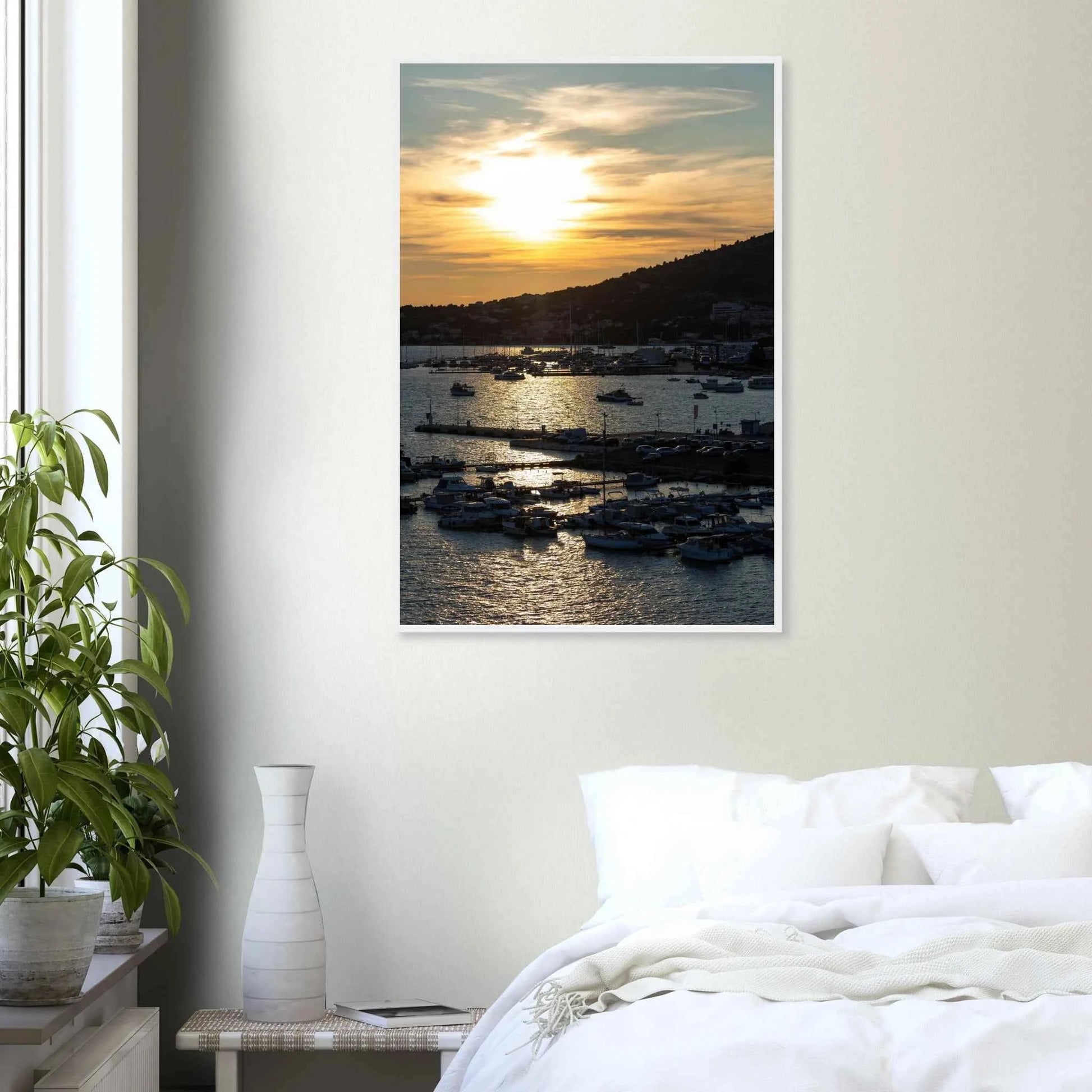 Wooden framed wall art of small boats anchored in a seaside port during Sunset at the harbor on the wall in the Bedroom