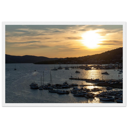 Wooden framed wall art of small boats anchored in a seaside port during Sunset at the harbor
