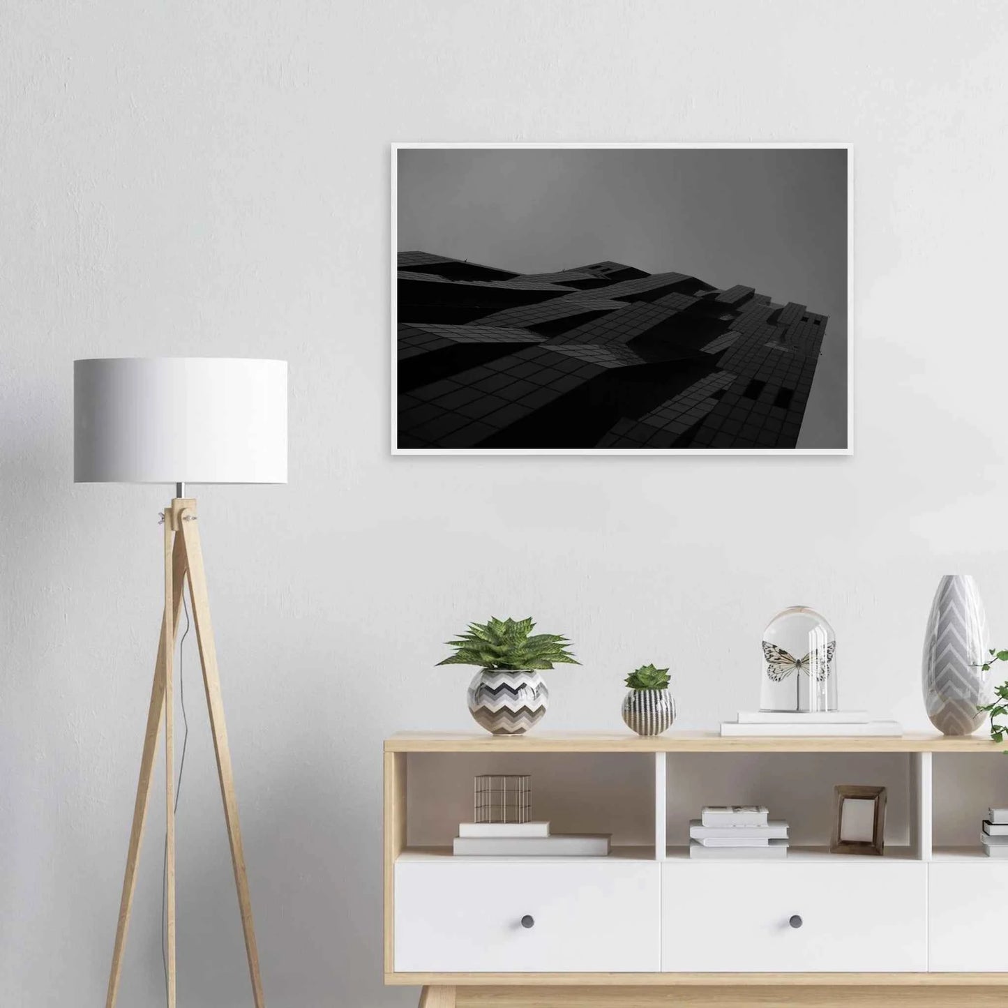 Black and white low angle view of a modern skyscraper with bold geometric lines and dark textured facade on wooden framed wall art on the wall in the Livingroom