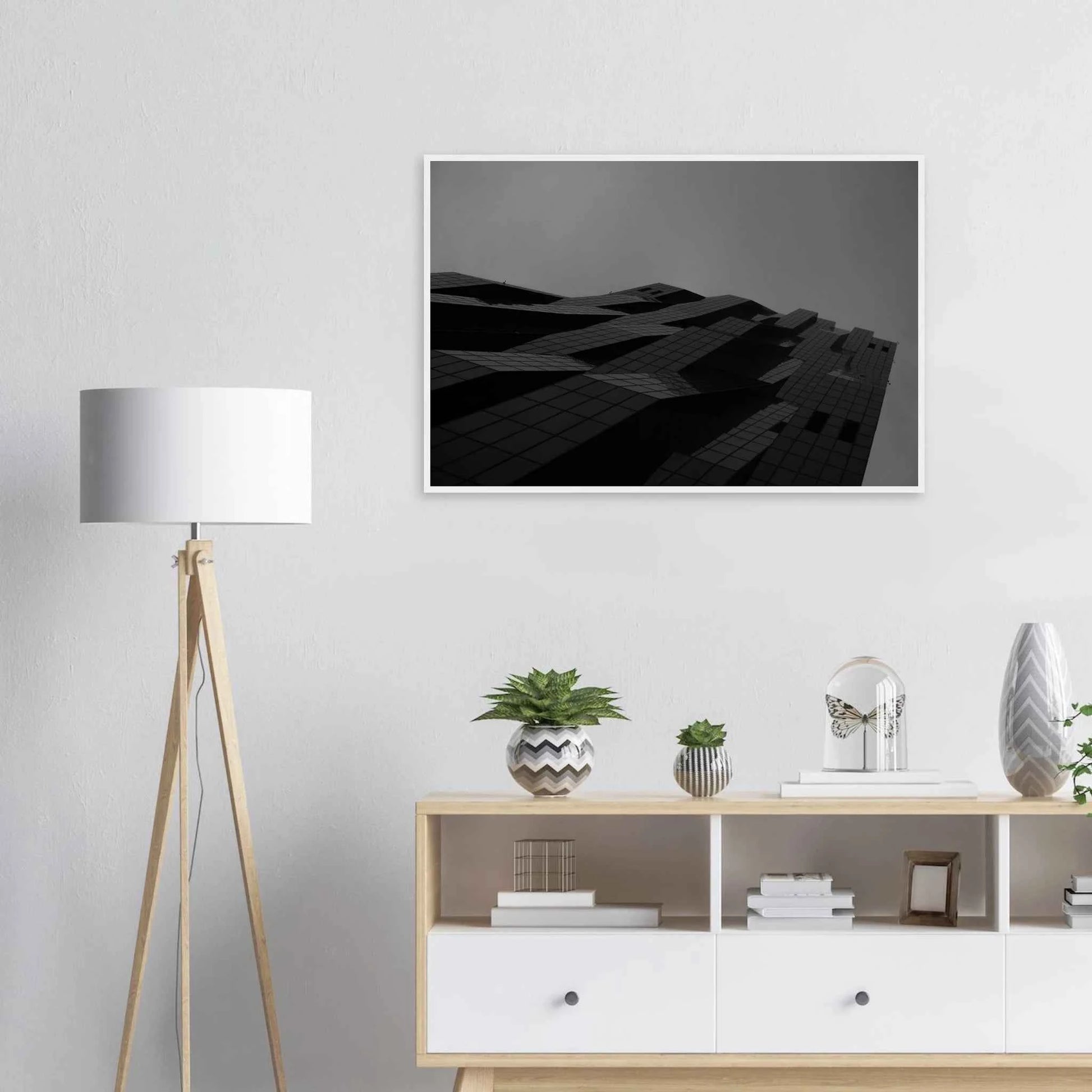 Black and white low angle view of a modern skyscraper with bold geometric lines and dark textured facade on wooden framed wall art on the wall in the Livingroom