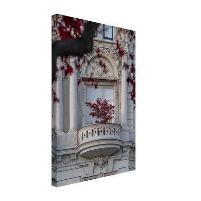 Red leaved tree in autumn colors in front of a historic stone building facade on Canvas Print wall art