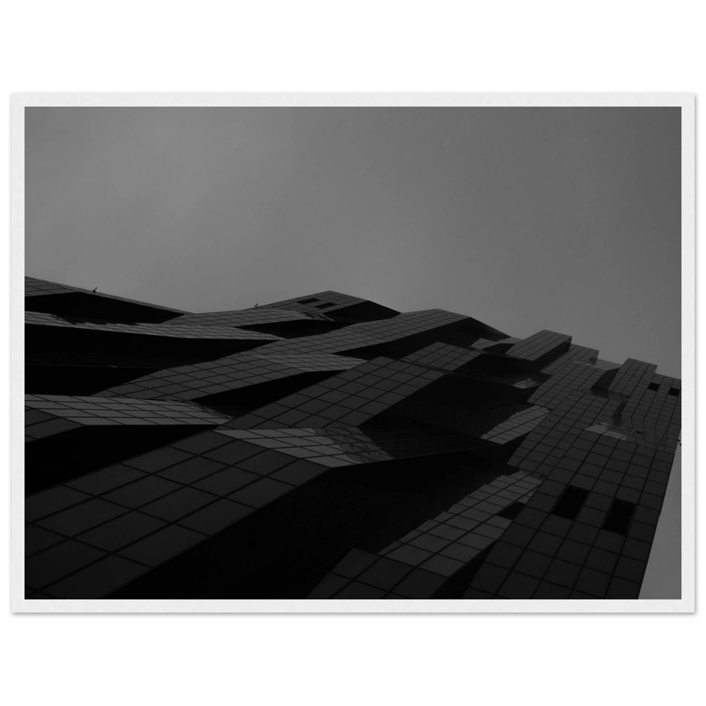Black and white low angle view of a modern skyscraper with bold geometric lines and dark textured facade on wooden framed wall art