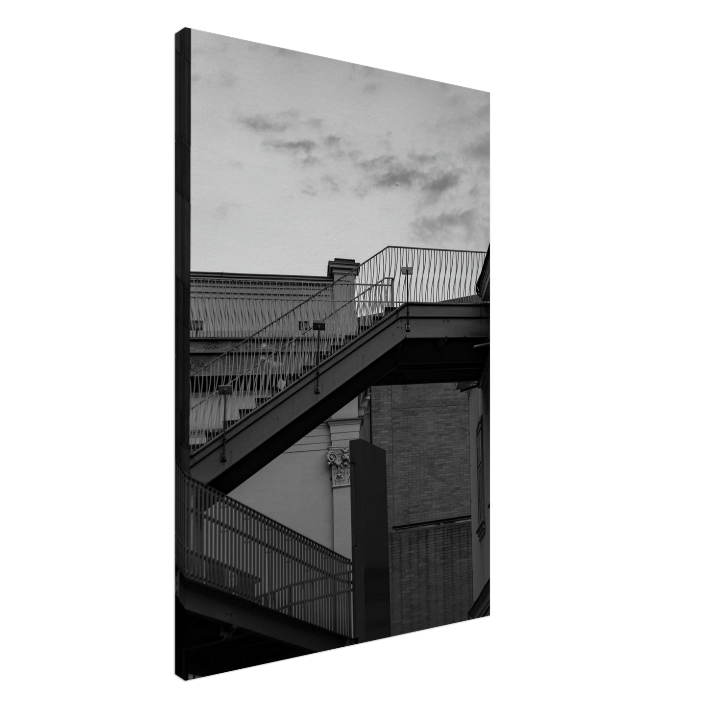 Black and white photo on a Canvas Print wall art of an outdoor staircase connecting two buildings under a dramatic cloudy sky