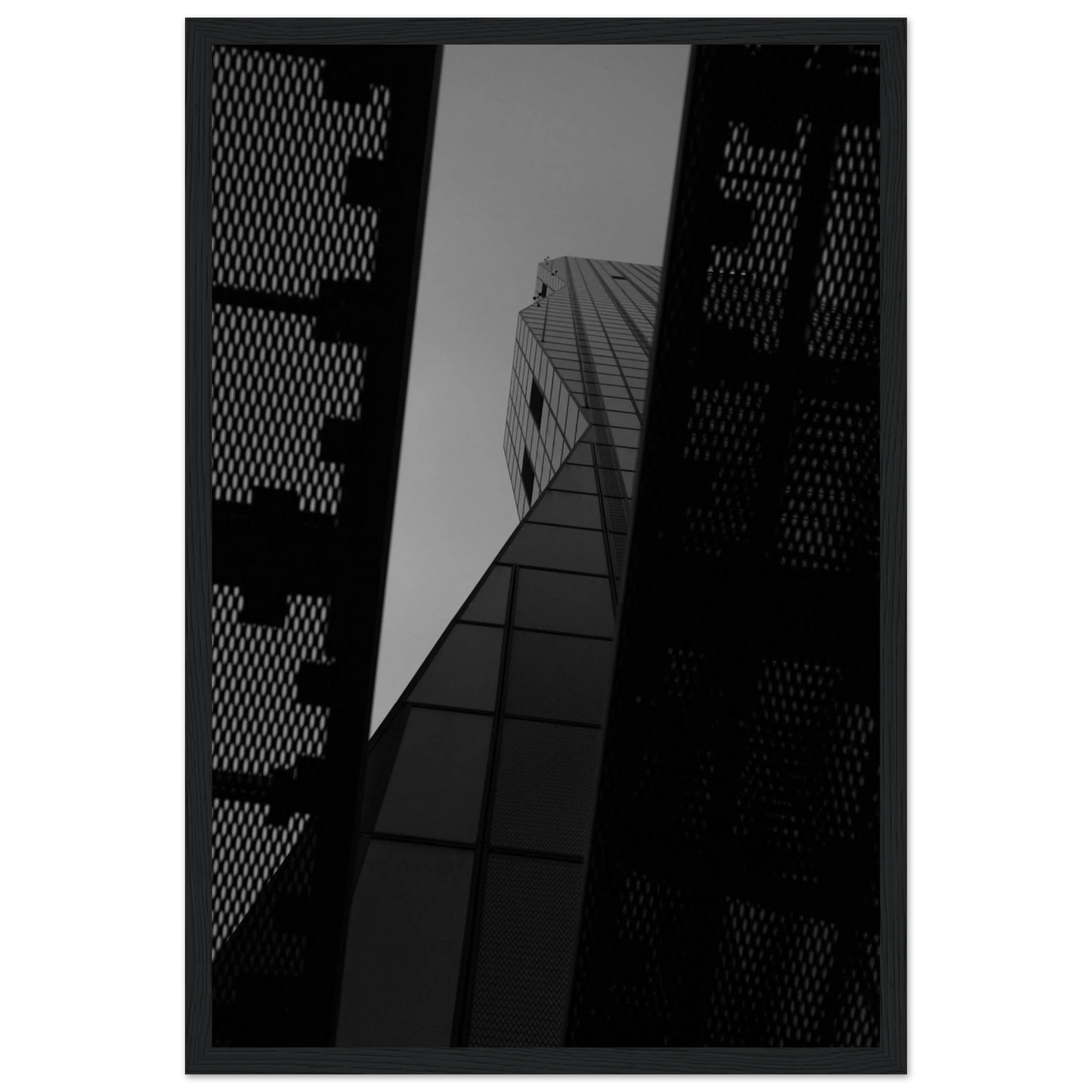 Black and white Low angle view looking up at a tall glass skyscraper framed between two metal structural elements on Wooden frame wall art