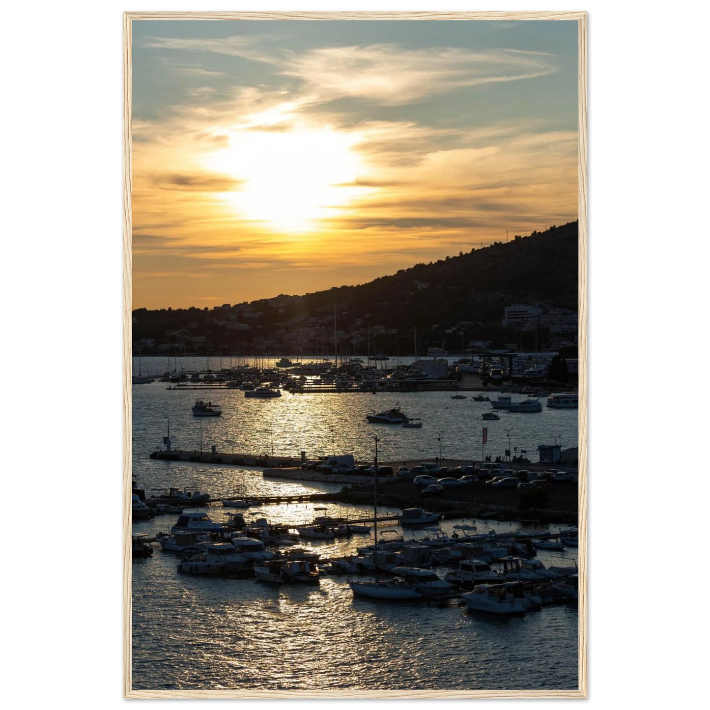 Wooden framed wall art of small boats anchored in a seaside port during Sunset at the harbor