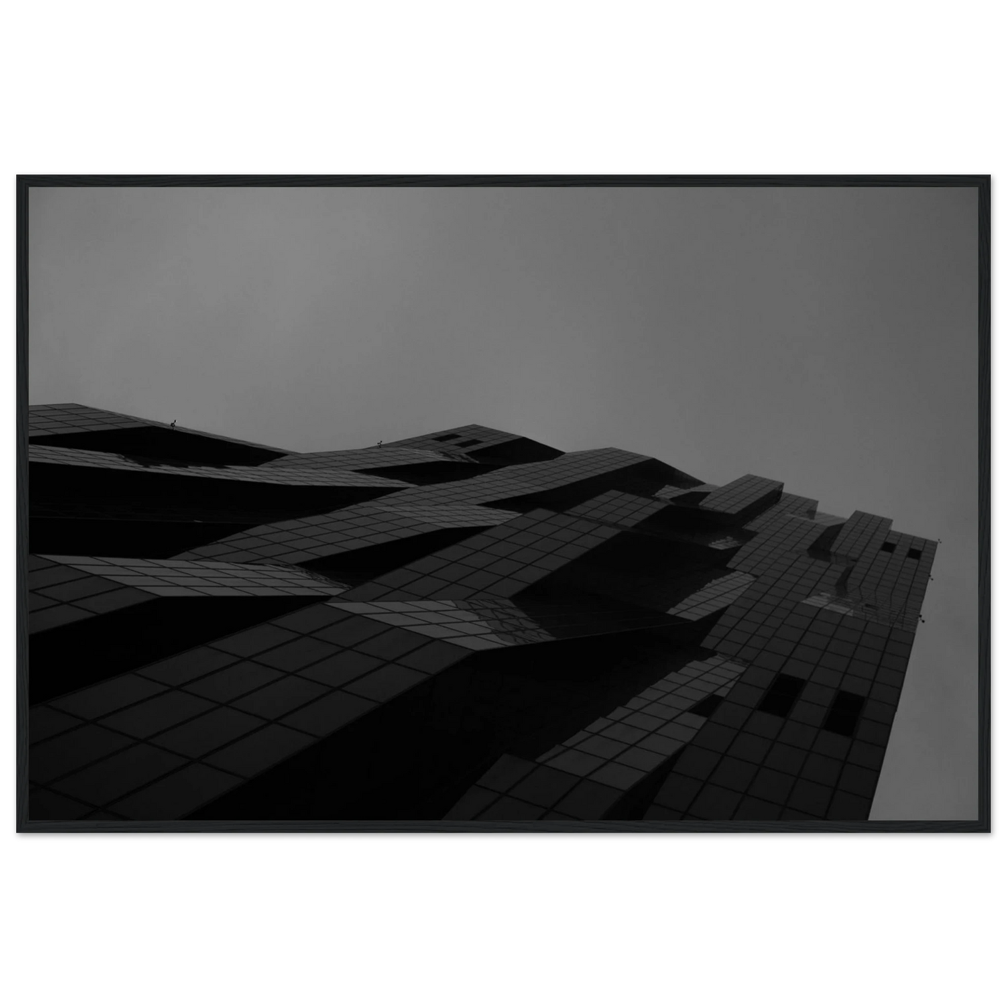 Black and white low angle view of a modern skyscraper with bold geometric lines and dark textured facade on wooden framed wall art