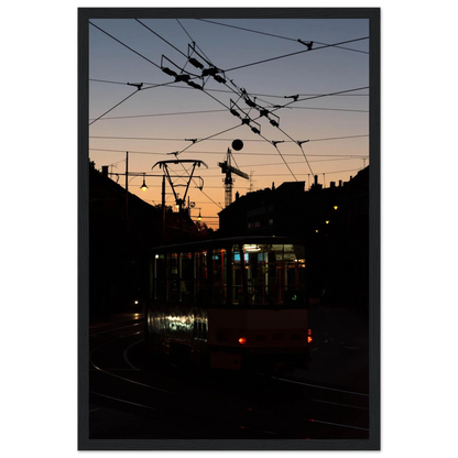Wooden framed wall art featuring a tram the Nightline driving between houses under power lines during a golden sunset