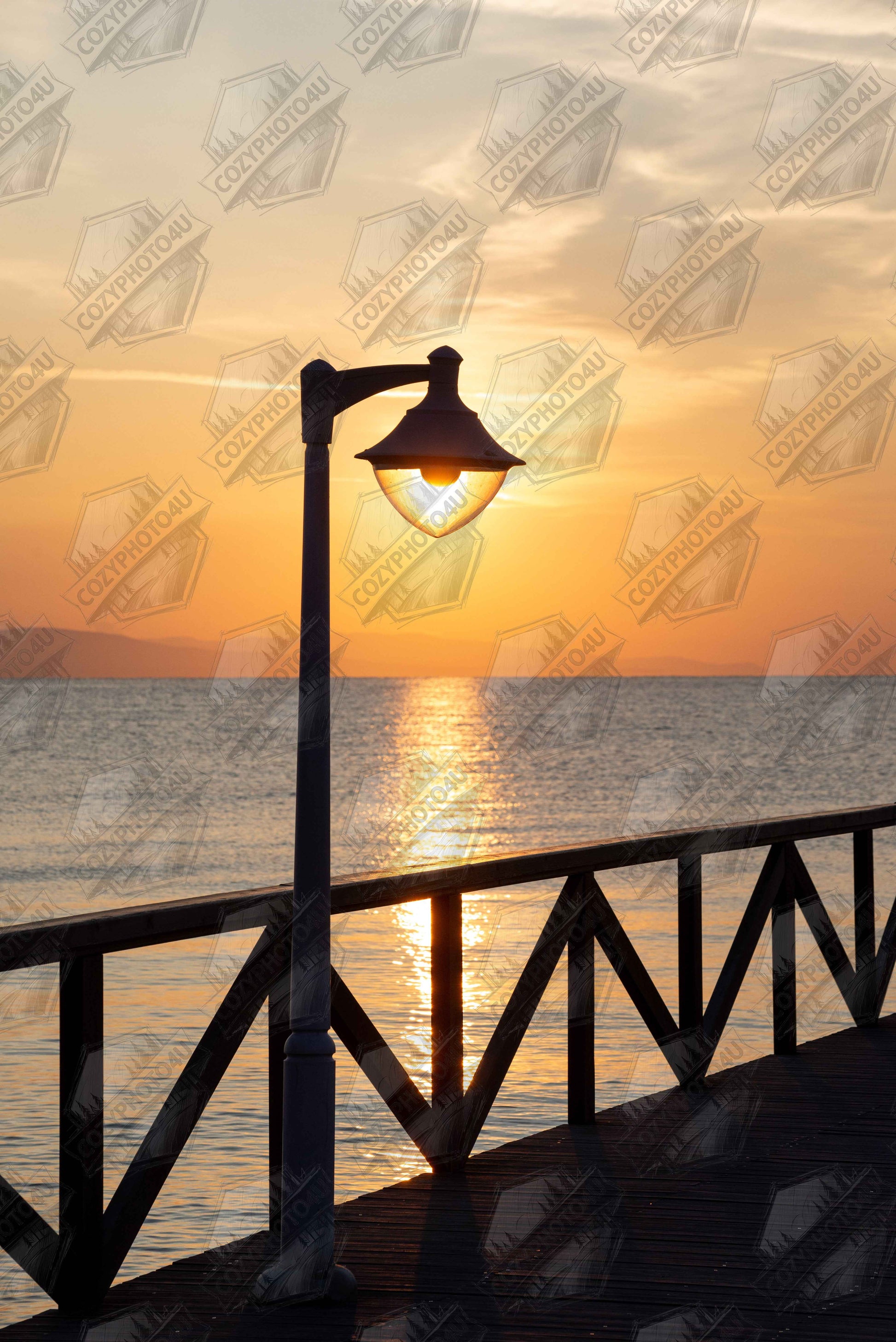 Digital picture of a sunset over the sea with a street lamp on the pier