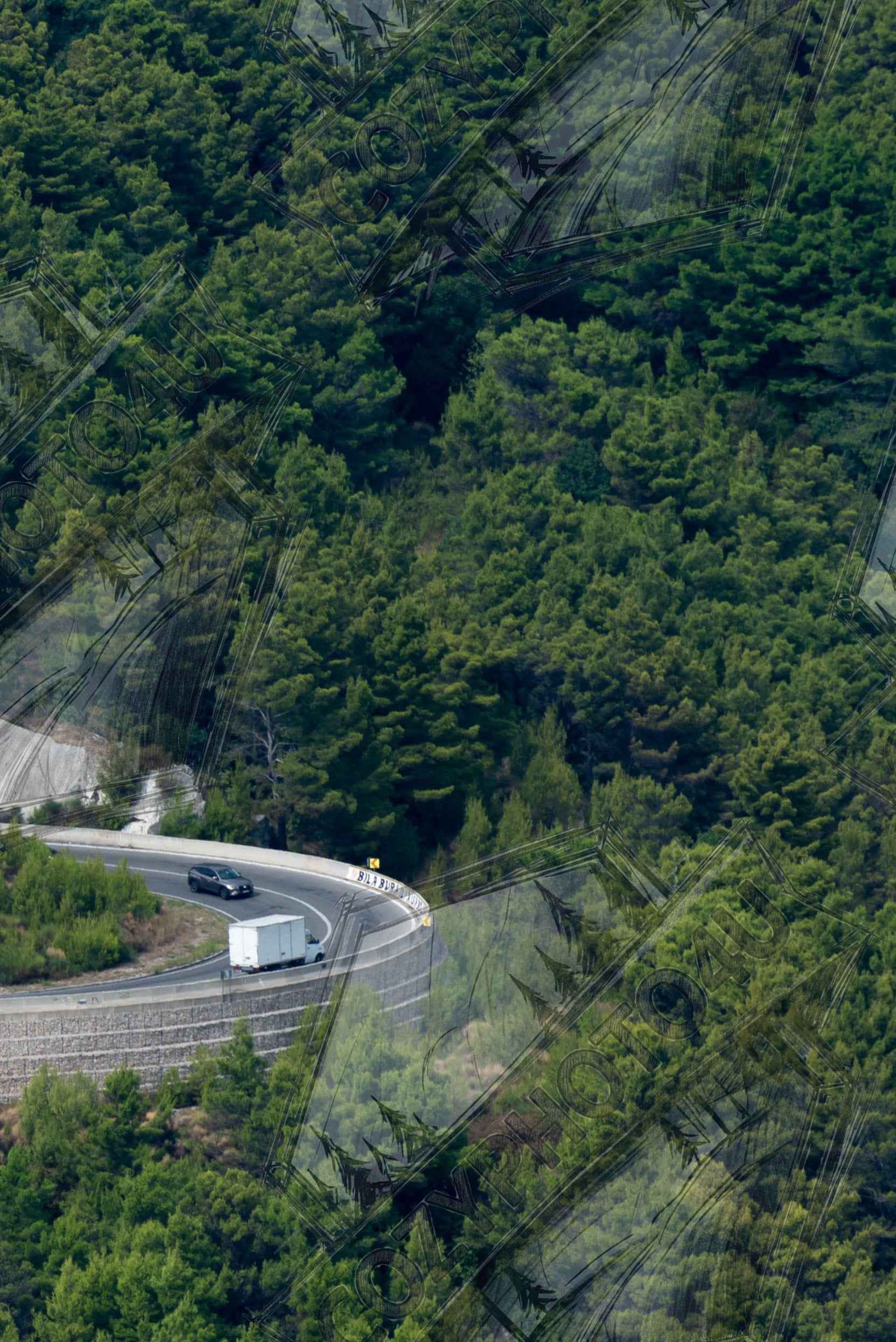 Digital Picture art Aerial view of a winding road curve with cars surrounded by lush green forest landscape