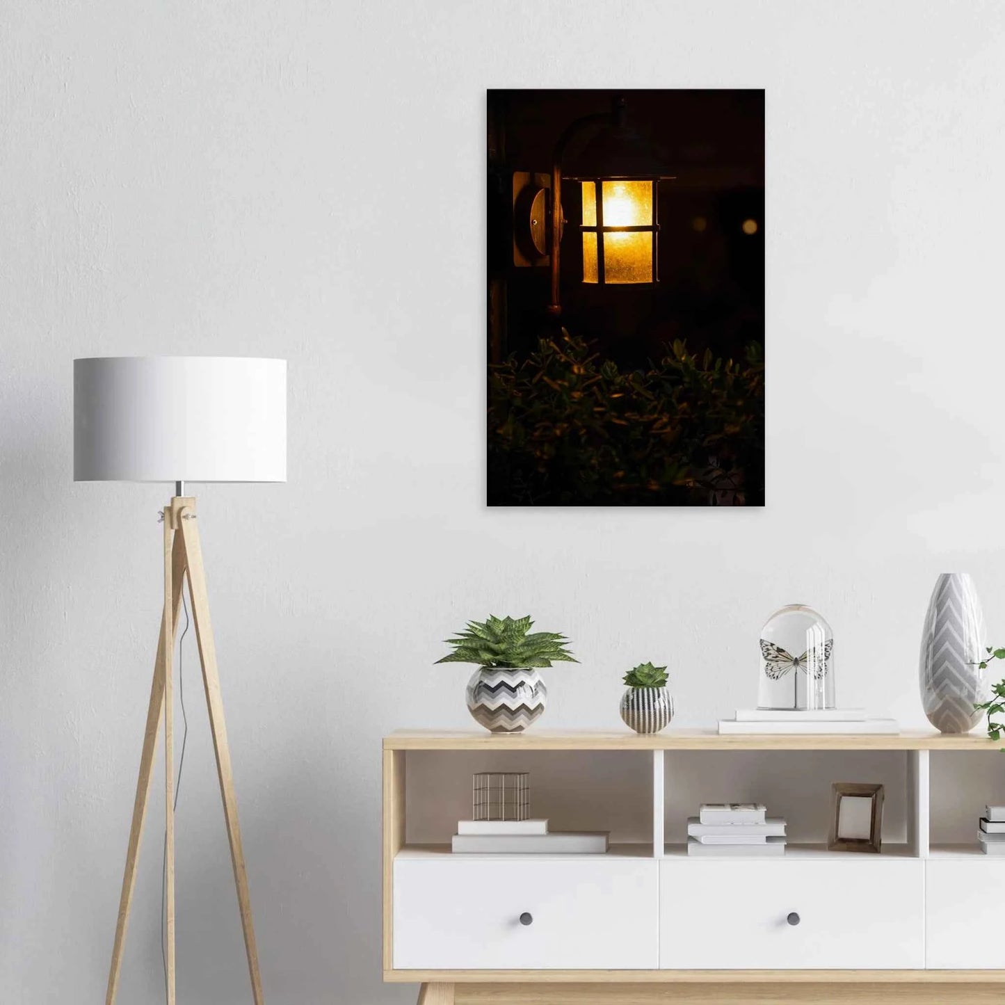 Glowing vintage lantern mounted on a wooden pole in front of a bush at night on Canvas Print wall art on the wall in the Livingroom