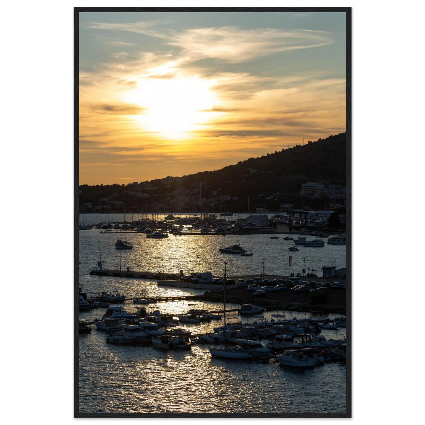 Wooden framed wall art of small boats anchored in a seaside port during Sunset at the harbor
