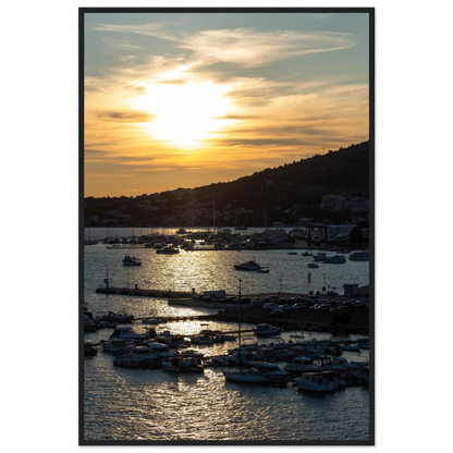 Wooden framed wall art of small boats anchored in a seaside port during Sunset at the harbor
