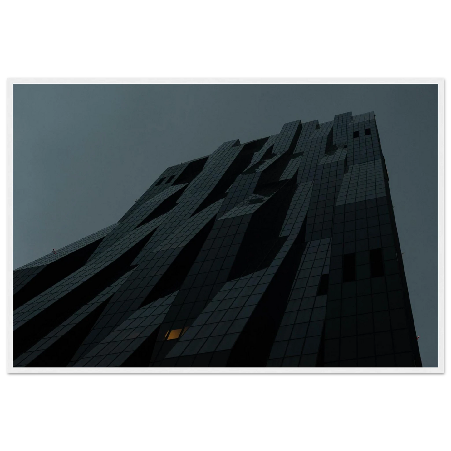 Bluish low angle view of a modern skyscraper with bold geometric lines and dark textured facade on Wooden framed wall art
