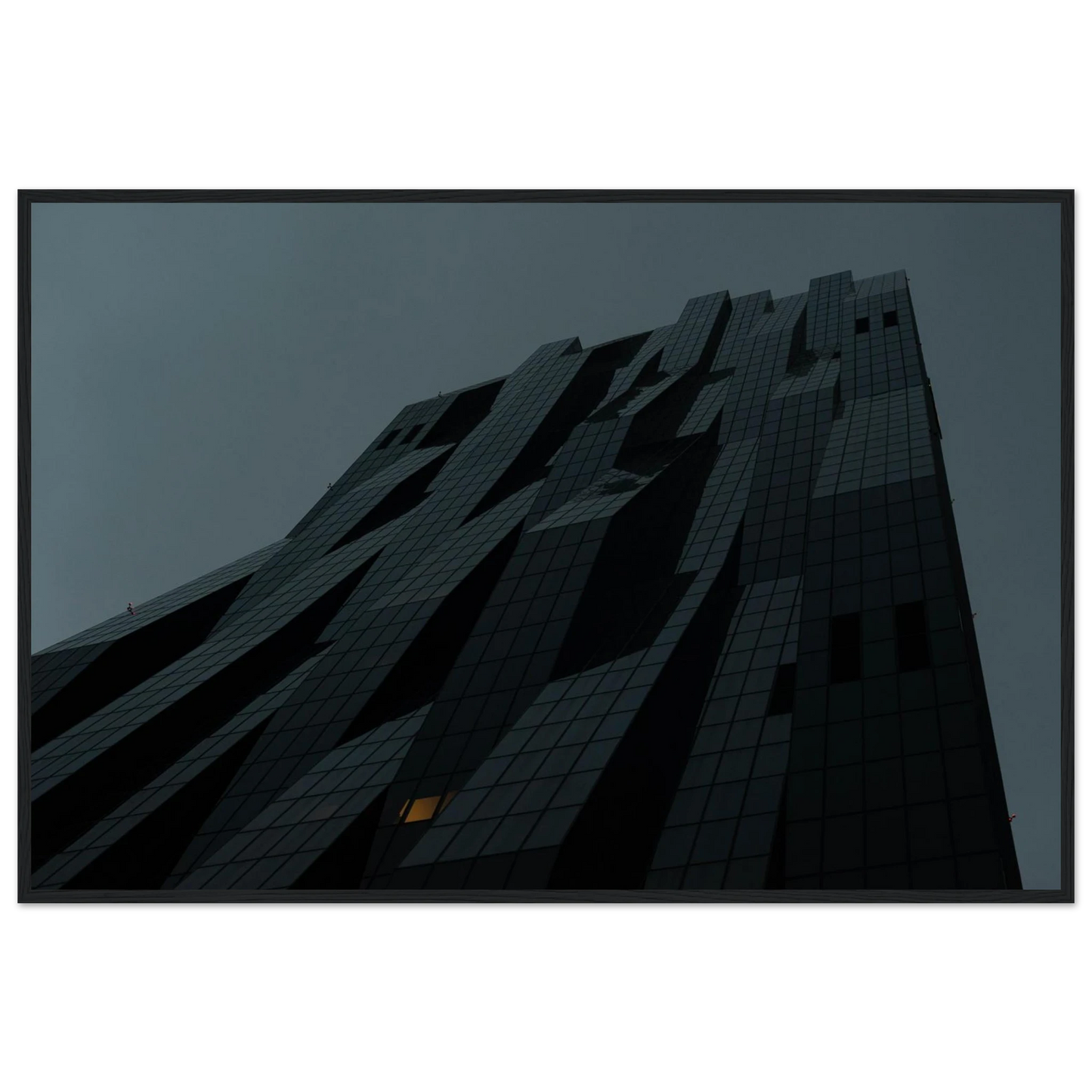 Bluish low angle view of a modern skyscraper with bold geometric lines and dark textured facade on Wooden framed wall art