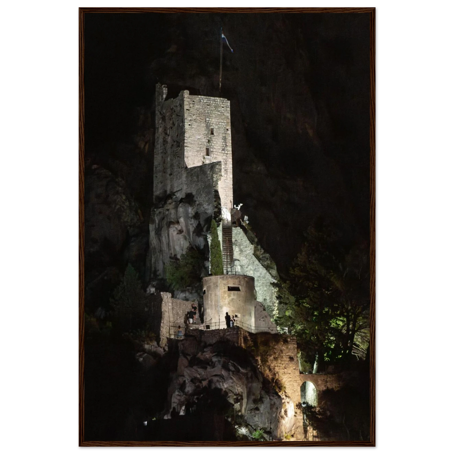Wooden framed wall art of an ancient stone bastion decorated with green climbing plants against a dark background in Shadow Keep
