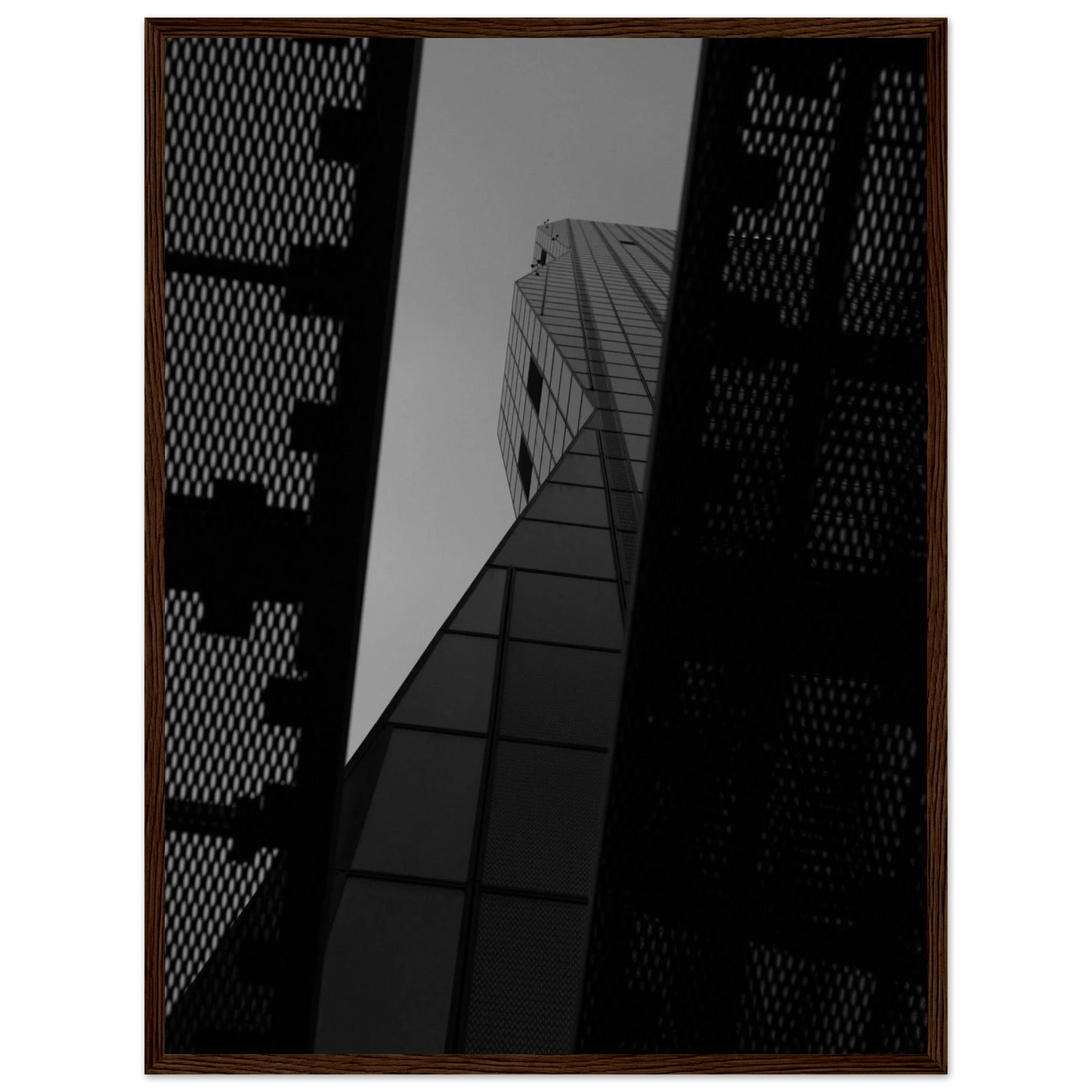 Black and white Low angle view looking up at a tall glass skyscraper framed between two metal structural elements on Wooden frame wall art