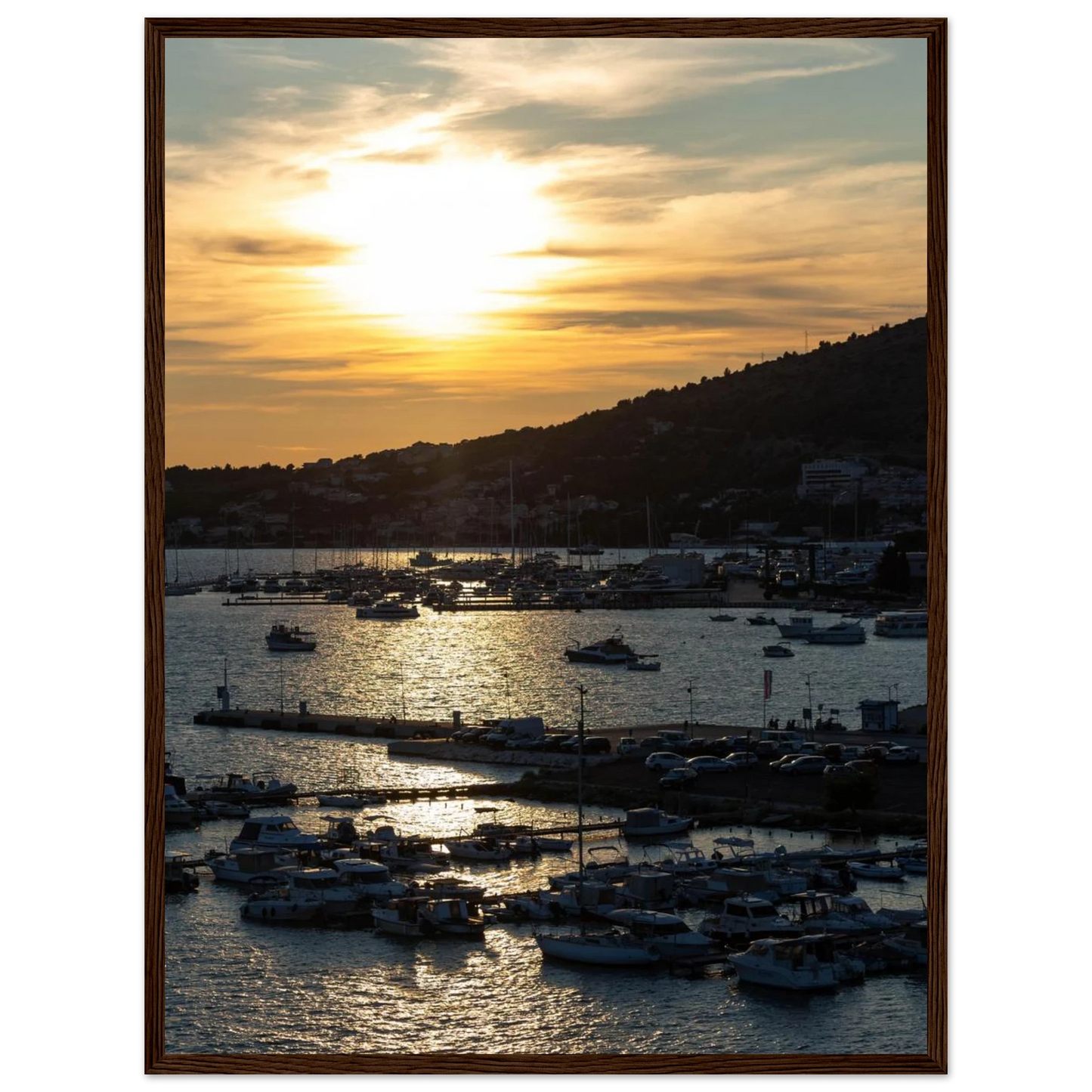 Wooden framed wall art of small boats anchored in a seaside port during Sunset at the harbor