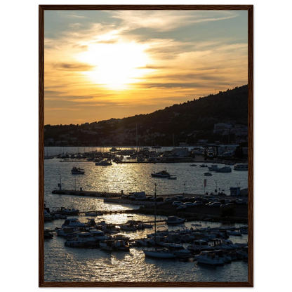 Wooden framed wall art of small boats anchored in a seaside port during Sunset at the harbor