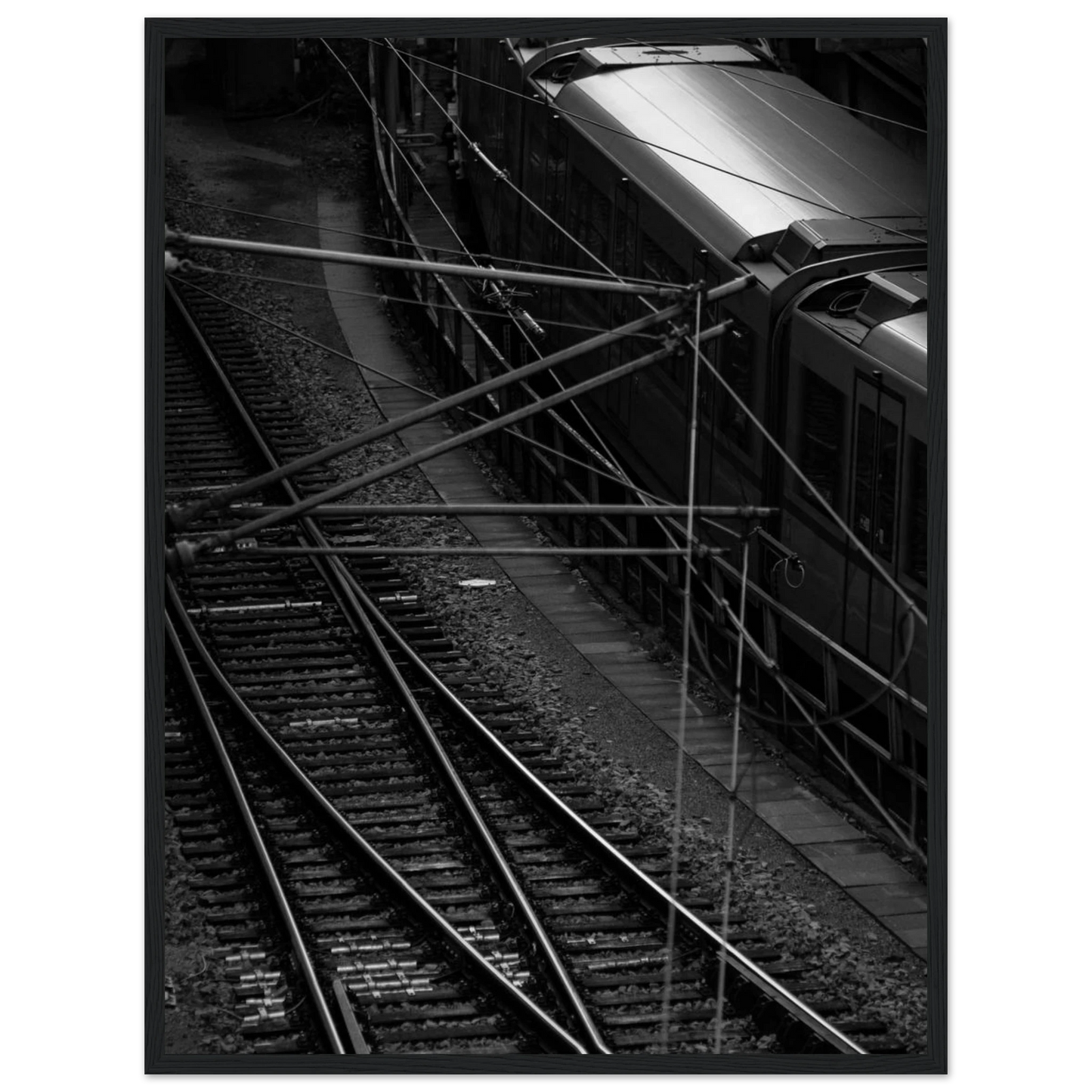Black and white aerial view of metro train and railway tracks in an urban underground or elevated rail system on wooden framed wall art