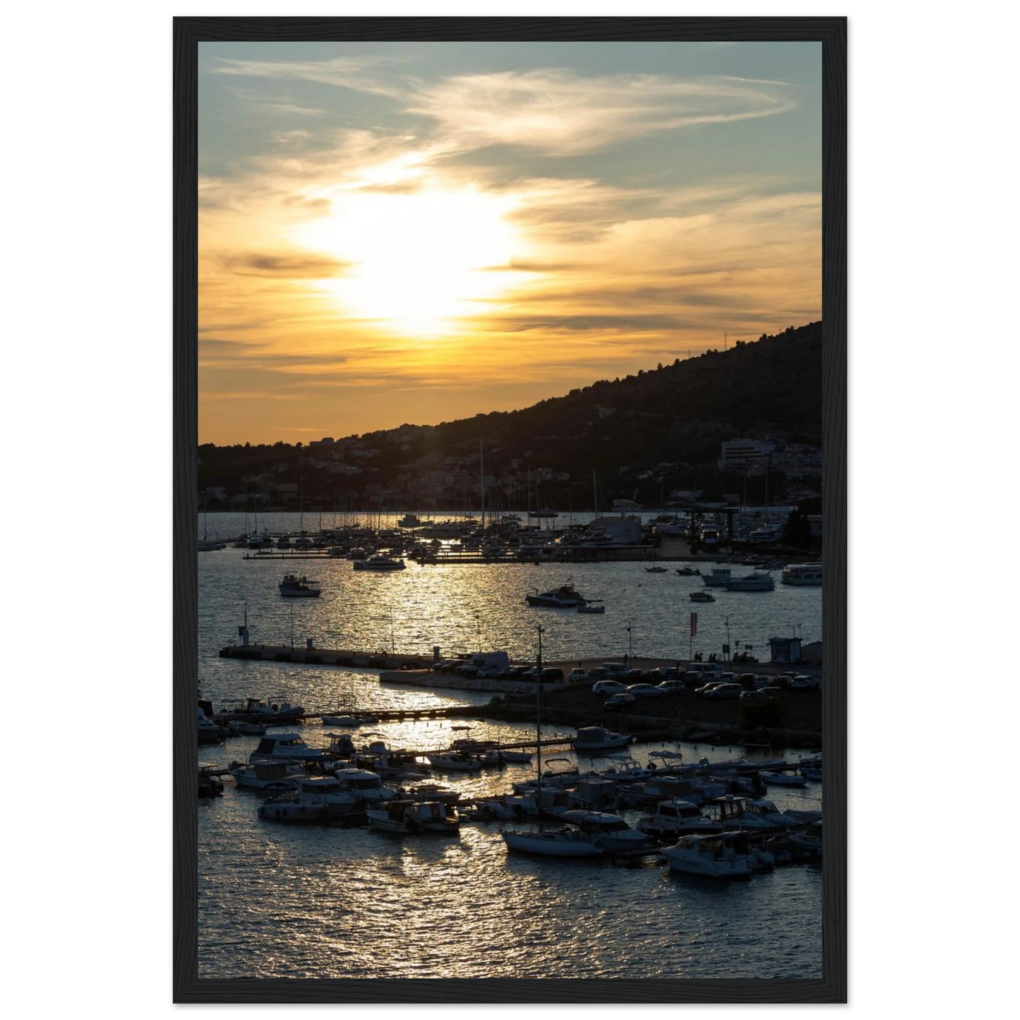 Wooden framed wall art of small boats anchored in a seaside port during Sunset at the harbor