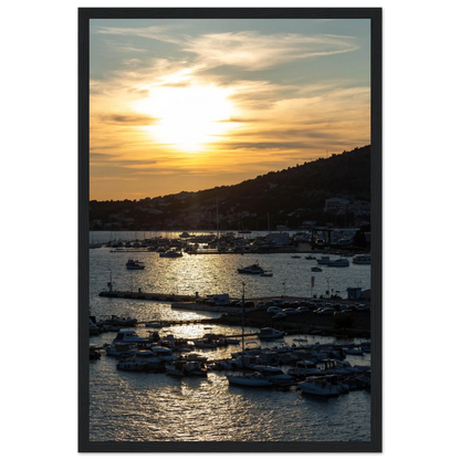 Wooden framed wall art of small boats anchored in a seaside port during Sunset at the harbor