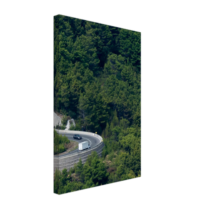 Aerial view of a winding road curve with cars surrounded by lush green forest landscape on Canvas print wall art