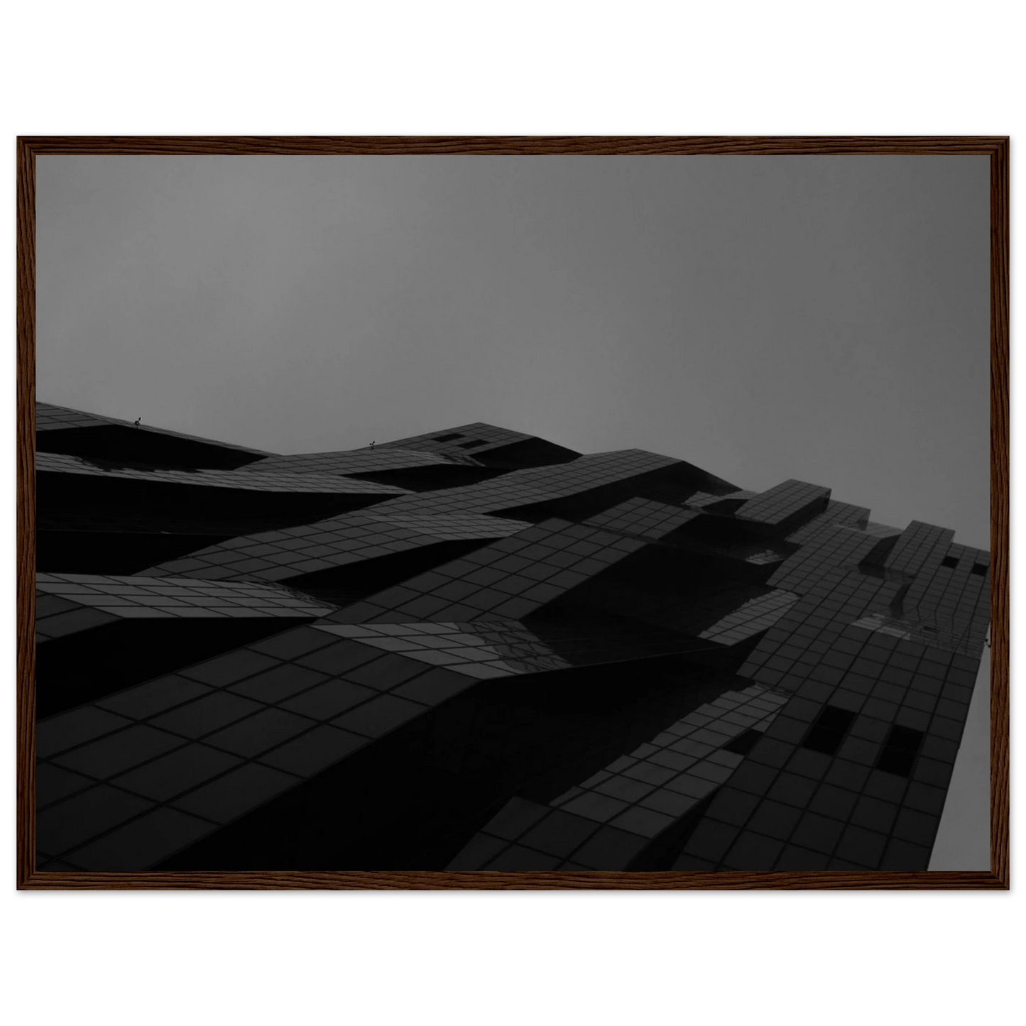 Black and white low angle view of a modern skyscraper with bold geometric lines and dark textured facade on wooden framed wall art