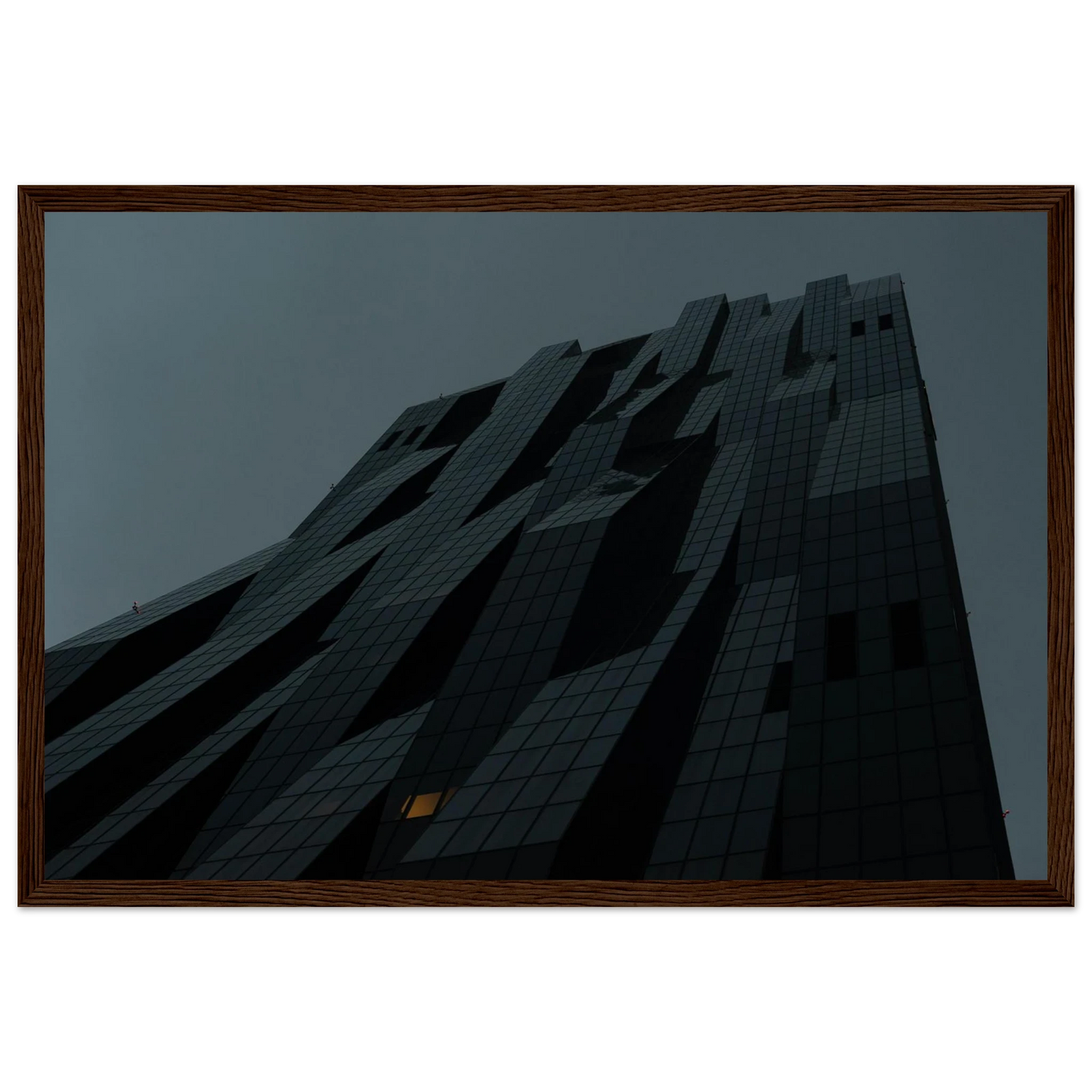 Bluish low angle view of a modern skyscraper with bold geometric lines and dark textured facade on Wooden framed wall art