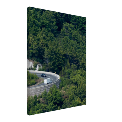 Aerial view of a winding road curve with cars surrounded by lush green forest landscape on Canvas print wall art