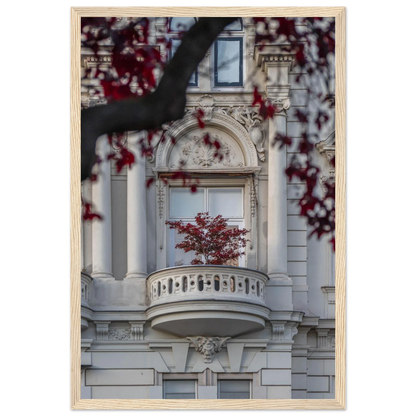 Red leaved tree in autumn colors in front of a historic stone building facade on wooden framed wall art