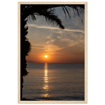 Wooden framed wall art Sunset over calm water with golden reflections, framed by tree branches in a peaceful natural landscape