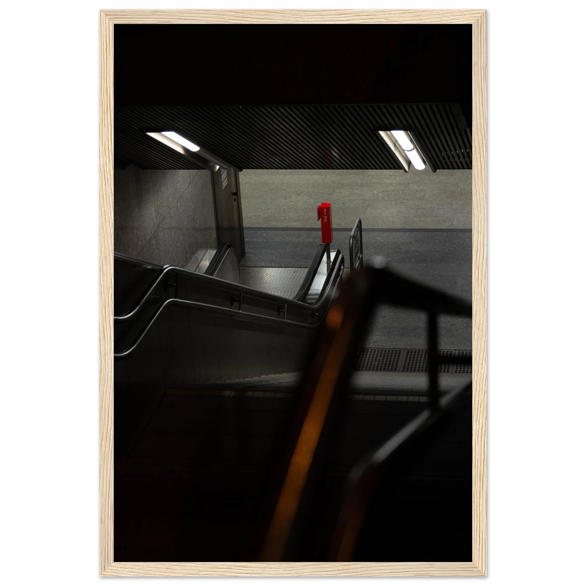 Nighttime view of a metro station entrance with illuminated signs and dark urban surroundings on wooden framed wall art