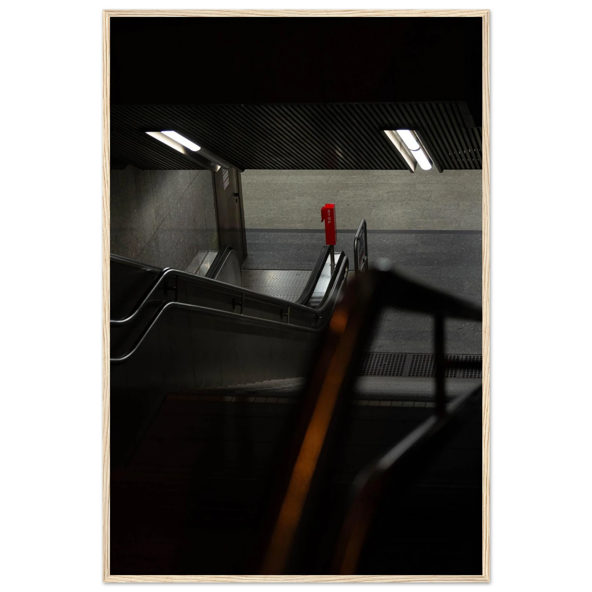 Nighttime view of a metro station entrance with illuminated signs and dark urban surroundings on wooden framed wall art