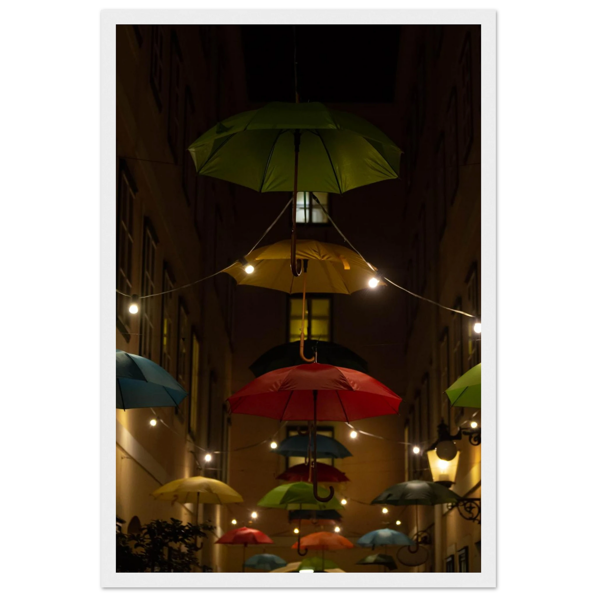 Nighttime street scene with colorful illuminated umbrellas hanging as decoration above a vibrant outdoor area on a wooden frame wall art