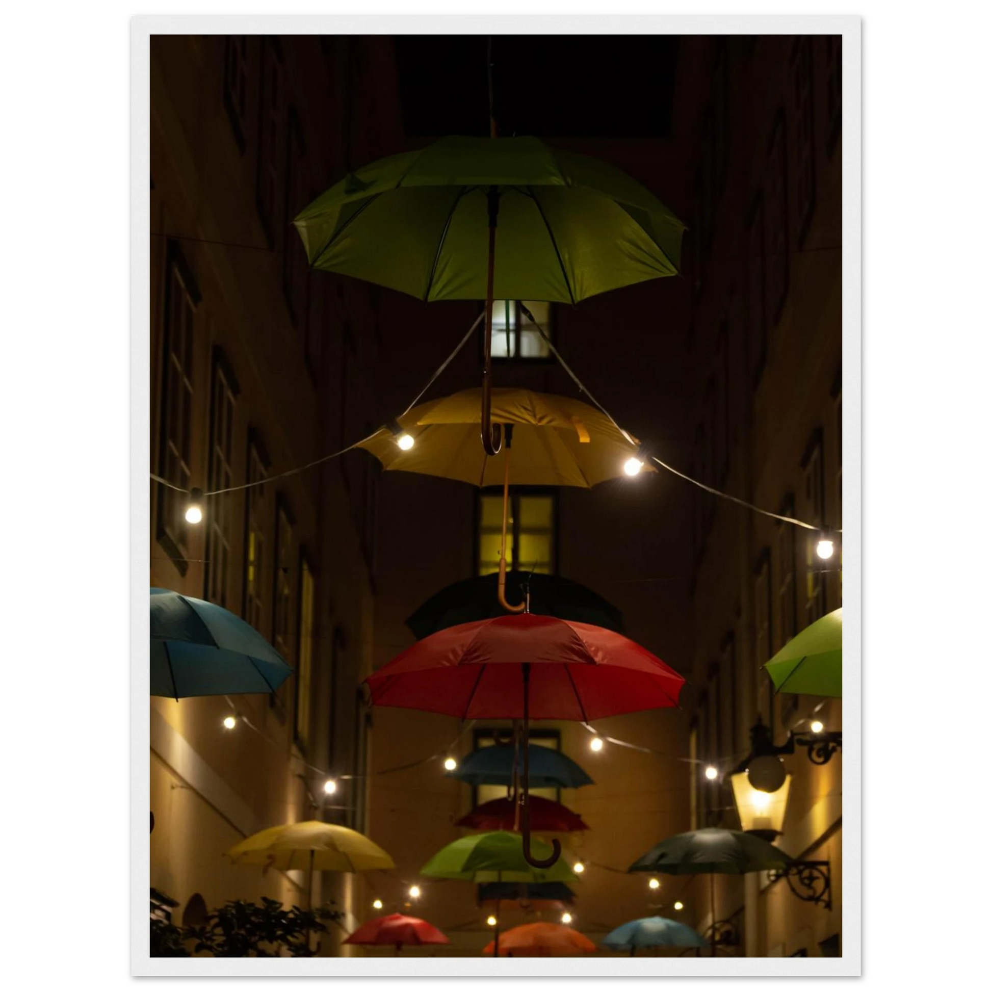 Nighttime street scene with colorful illuminated umbrellas hanging as decoration above a vibrant outdoor area on a wooden frame wall art