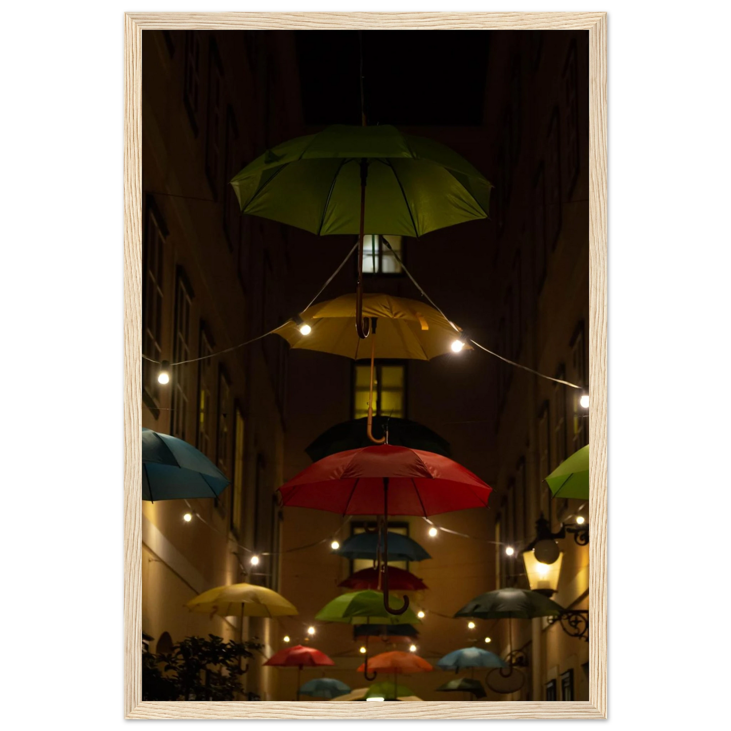 Nighttime street scene with colorful illuminated umbrellas hanging as decoration above a vibrant outdoor area on a wooden frame wall art