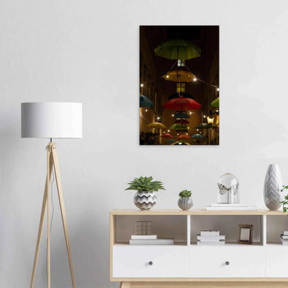 Nighttime street scene with colorful illuminated umbrellas hanging as decoration above a vibrant outdoor area on a wooden frame wall art on the wall in the Livingroom