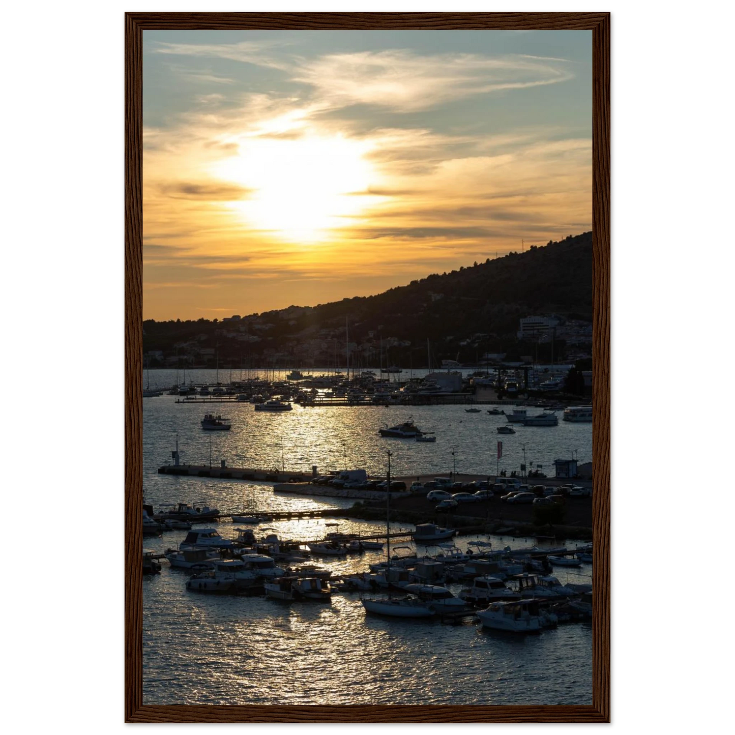 Wooden framed wall art of small boats anchored in a seaside port during Sunset at the harbor
