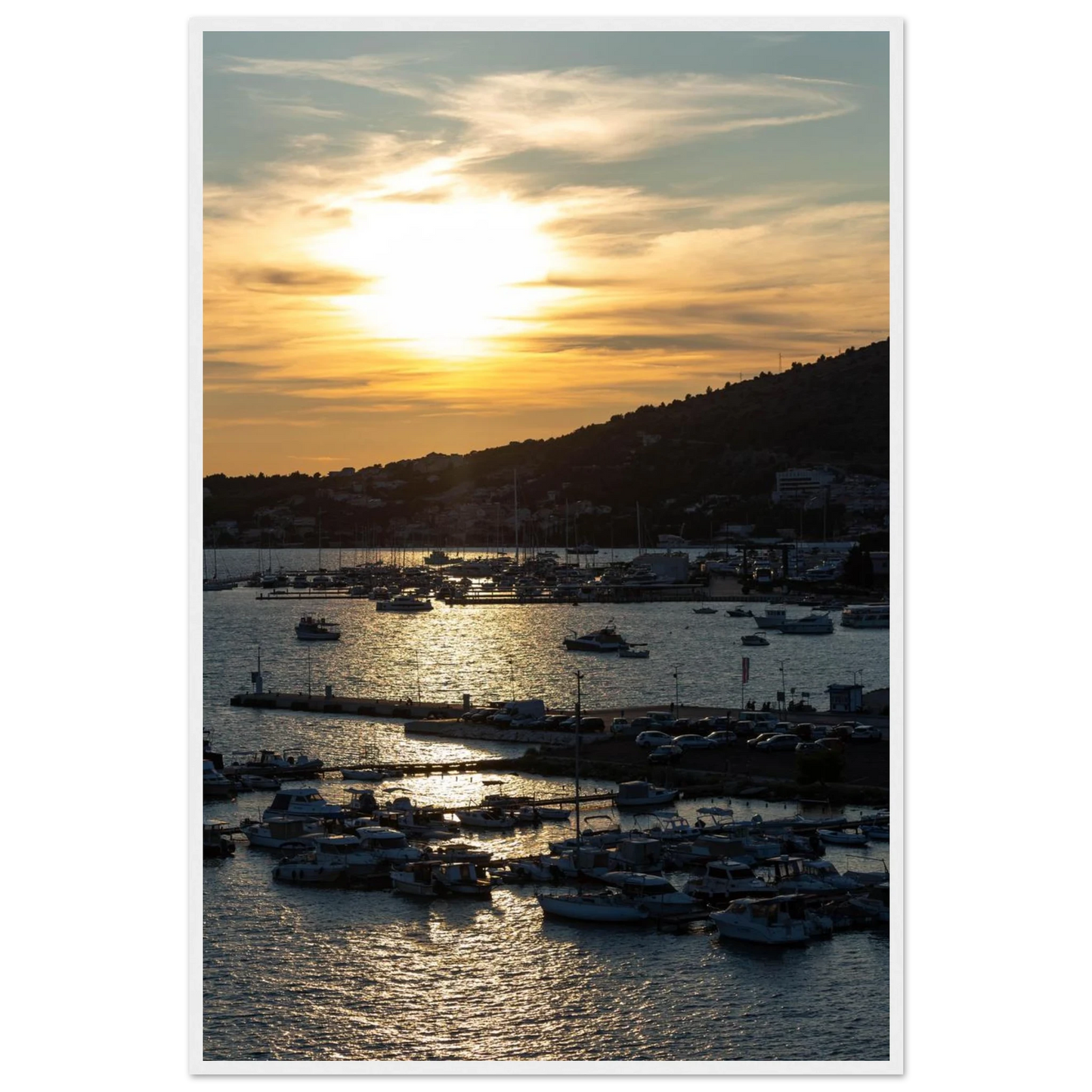 Wooden framed wall art of small boats anchored in a seaside port during Sunset at the harbor