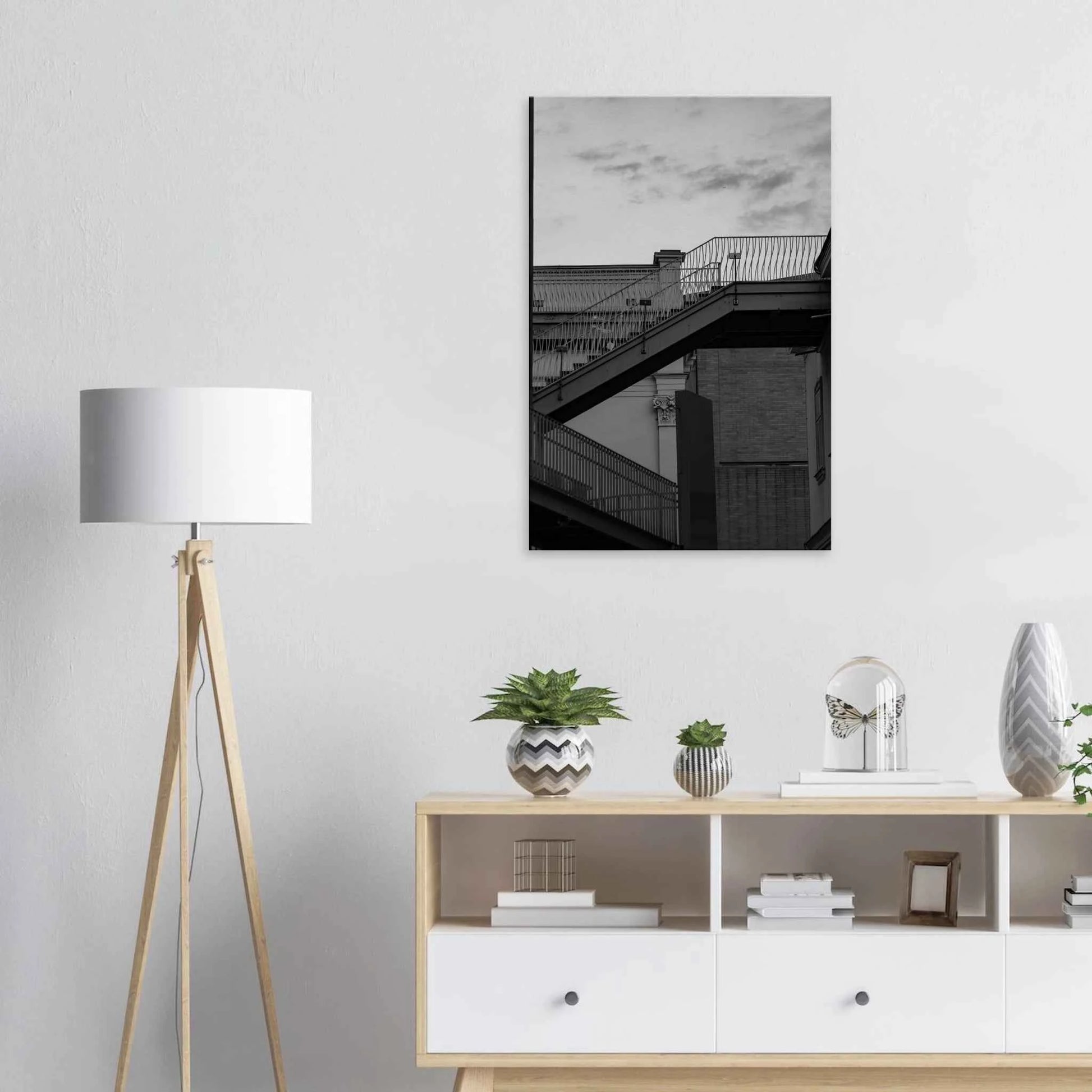 Black and white photo on a Canvas Print wall art of an outdoor staircase connecting two buildings under a dramatic cloudy sky on the wall in the Livingroom