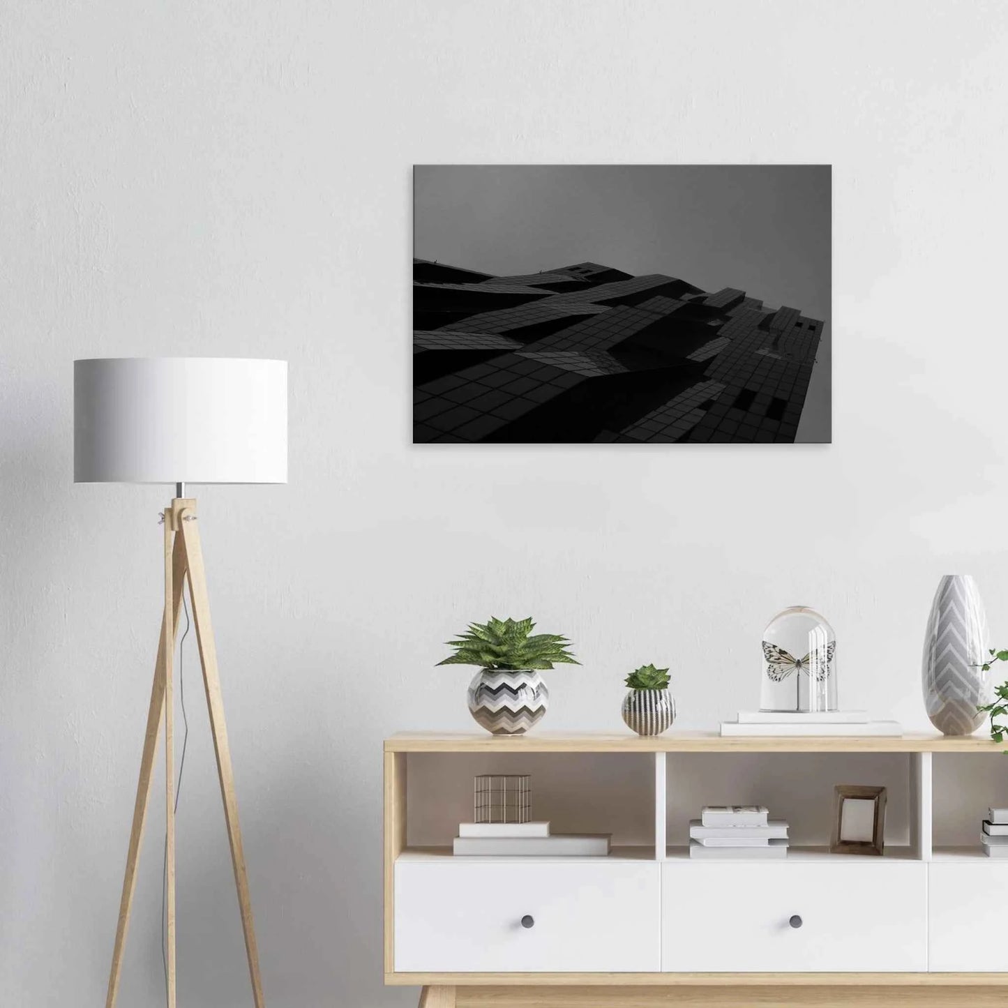 Black and white low angle view of a modern skyscraper with bold geometric lines and dark textured facade on Canvas Print wall art on the wall in the Livingroom
