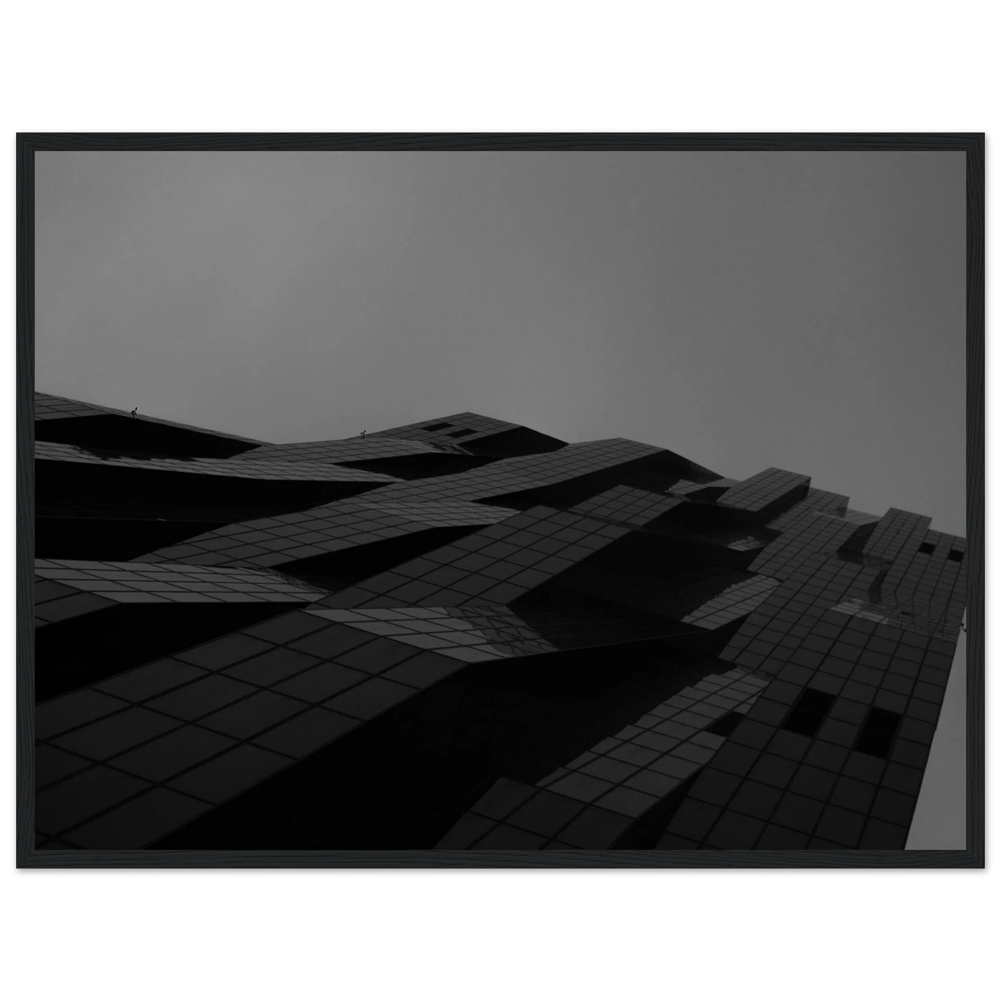 Black and white low angle view of a modern skyscraper with bold geometric lines and dark textured facade on wooden framed wall art