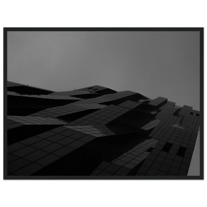 Black and white low angle view of a modern skyscraper with bold geometric lines and dark textured facade on wooden framed wall art