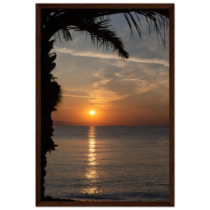 Wooden framed wall art Sunset over calm water with golden reflections, framed by tree branches in a peaceful natural landscape