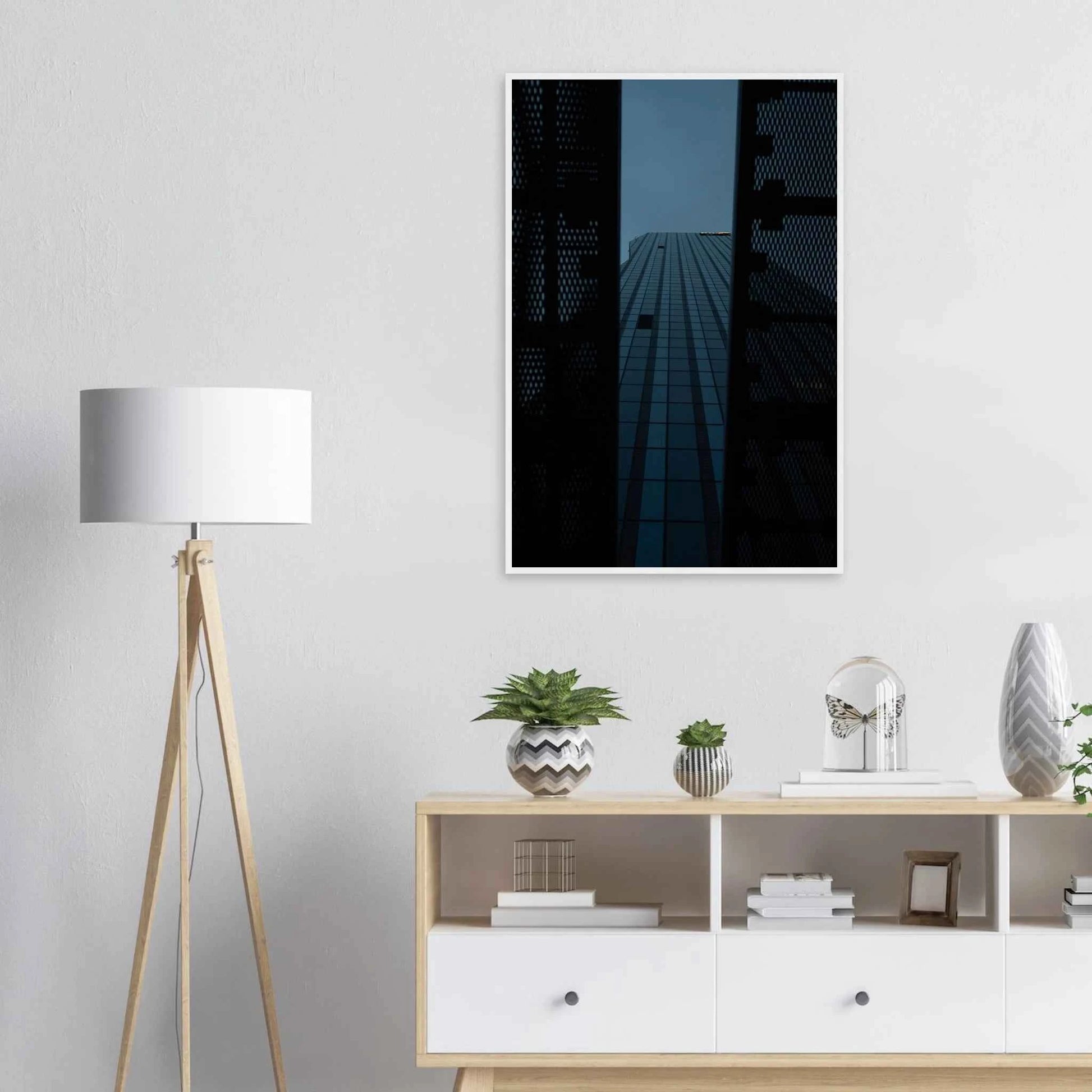 Low angle view looking up at a tall glass skyscraper framed between two metal structural elements on wooden framed wall art on the wall in the Livingroom