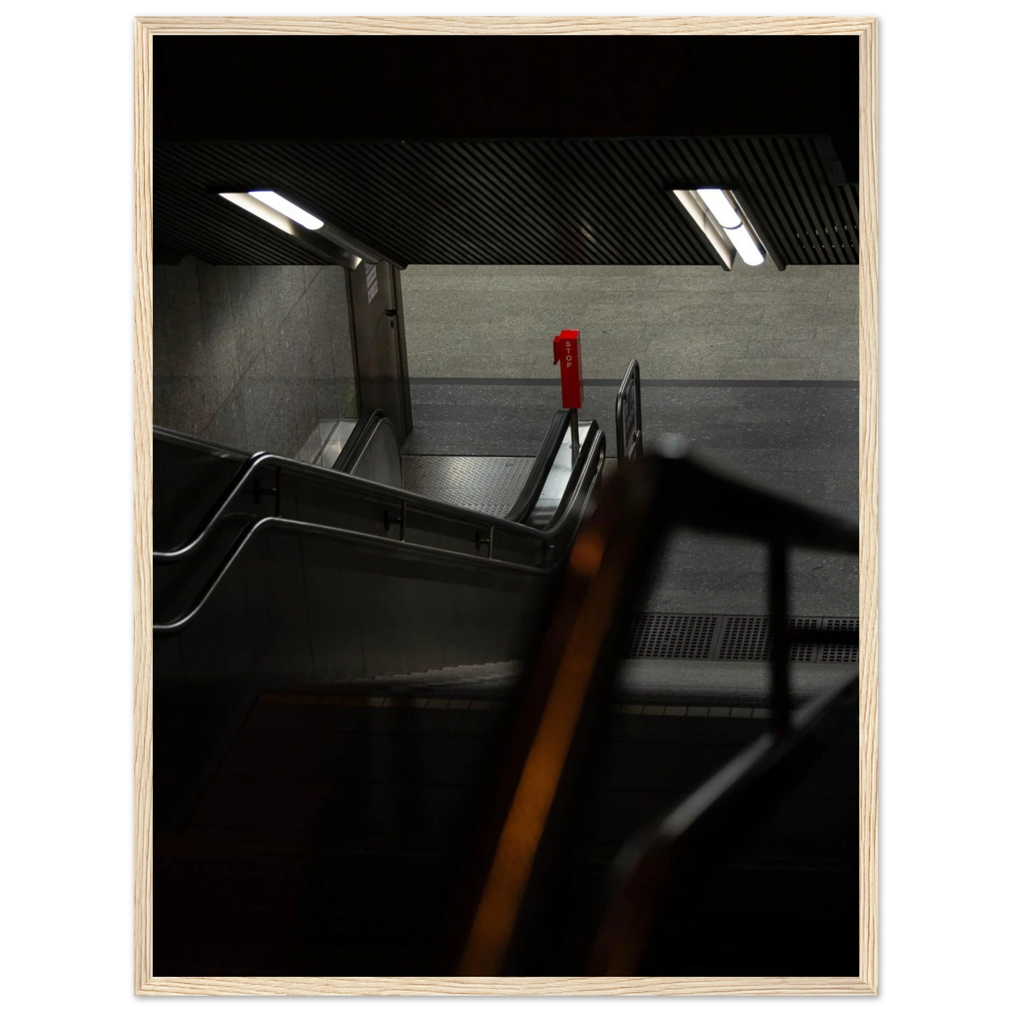 Nighttime view of a metro station entrance with illuminated signs and dark urban surroundings on wooden framed wall art