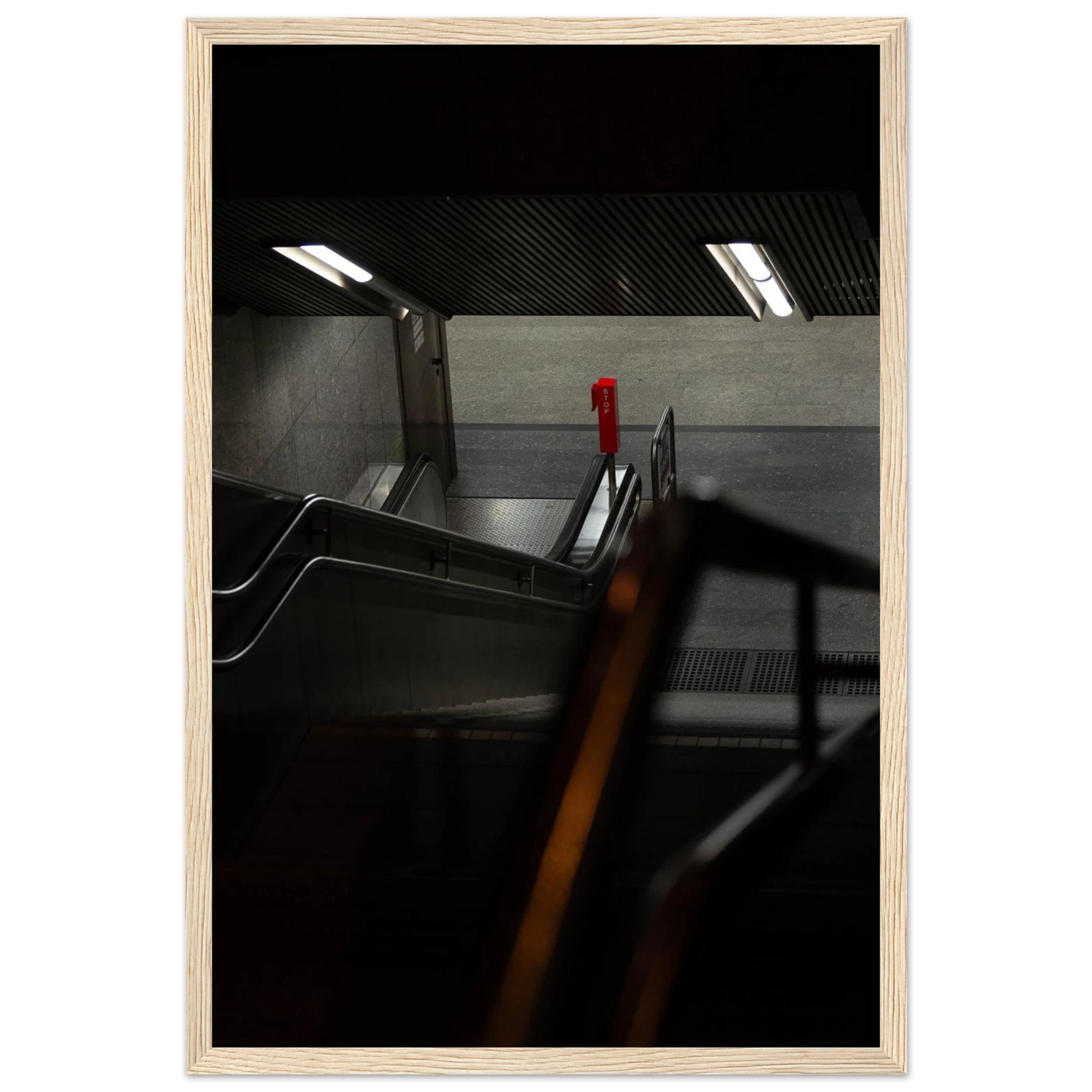 Nighttime view of a metro station entrance with illuminated signs and dark urban surroundings on wooden framed wall art