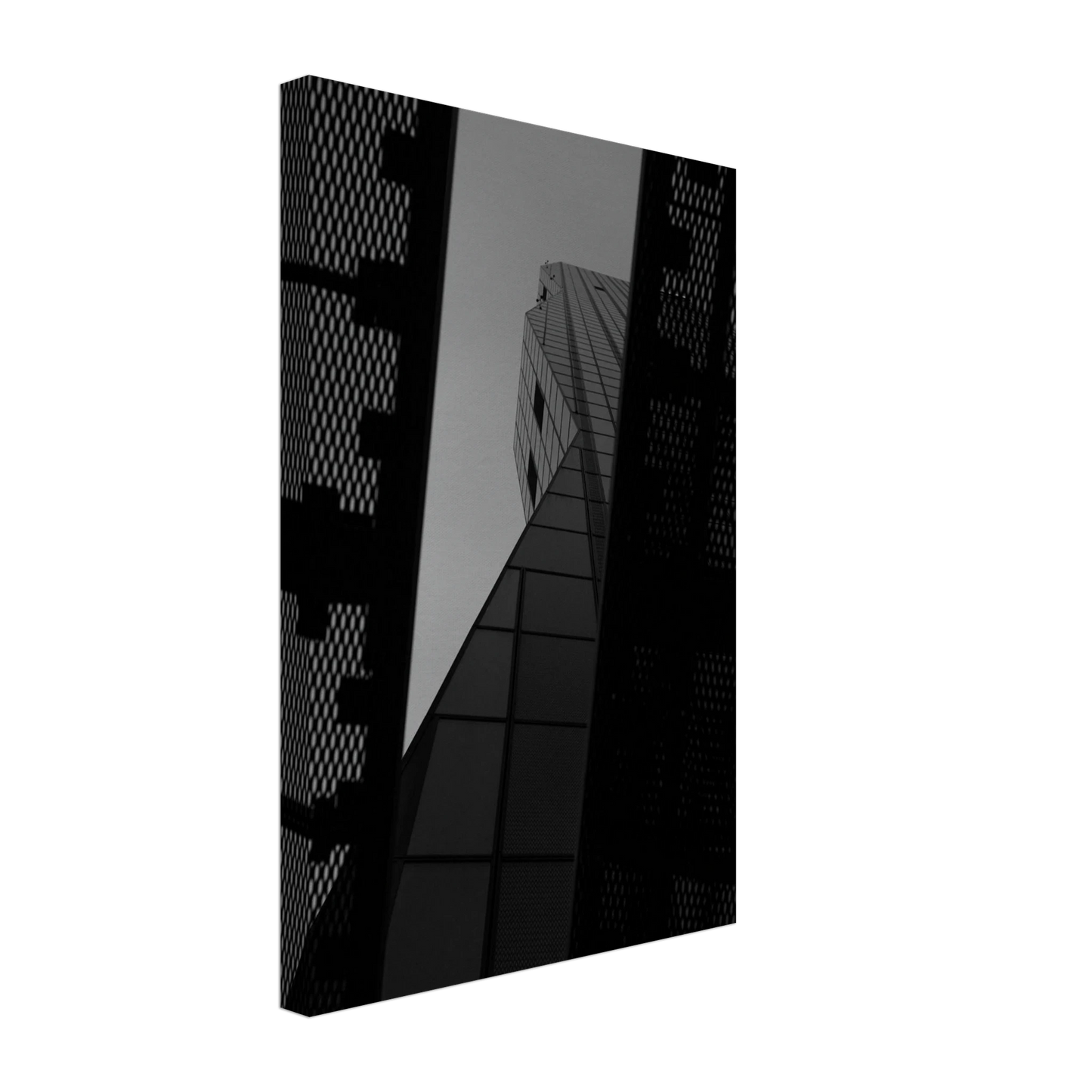 Black and white Low angle view looking up at a tall glass skyscraper framed between two metal structural elements on Canvas Print wall art
