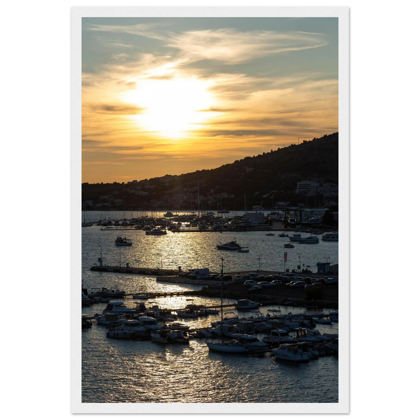Wooden framed wall art of small boats anchored in a seaside port during Sunset at the harbor