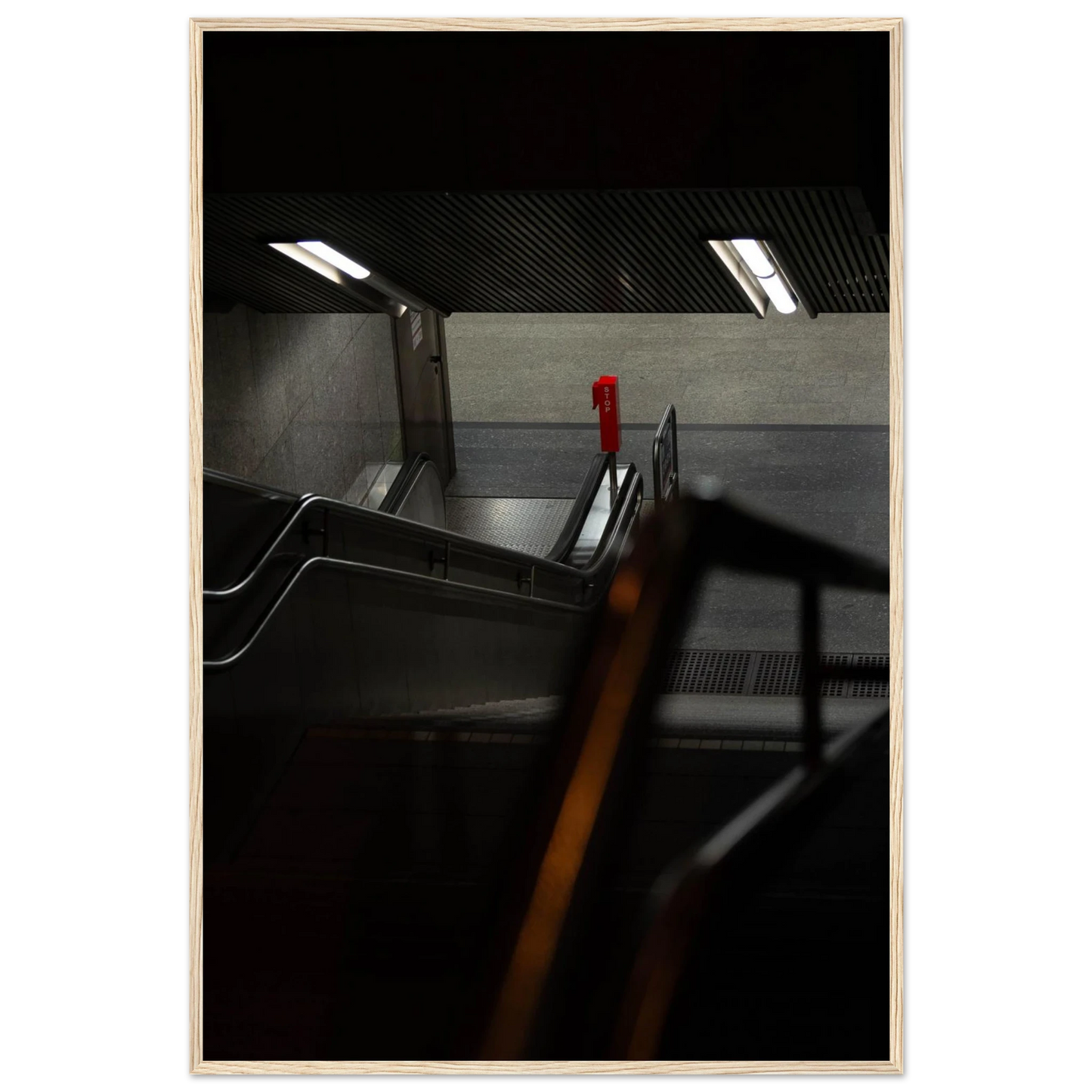 Nighttime view of a metro station entrance with illuminated signs and dark urban surroundings on wooden framed wall art